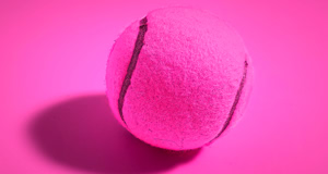 Ein pinker Tennisball auf einem pinken Hintergrund.