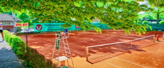 Ein Tennisplatz mit rotem Sand, umgeben von gr&uuml;nen B&auml;umen und Str&auml;uchern, im Hintergrund ein Geb&auml;ude und ein Weg mit Personen.