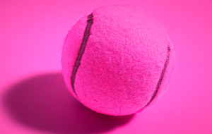 Ein pinker Tennisball auf einem pinken Hintergrund.