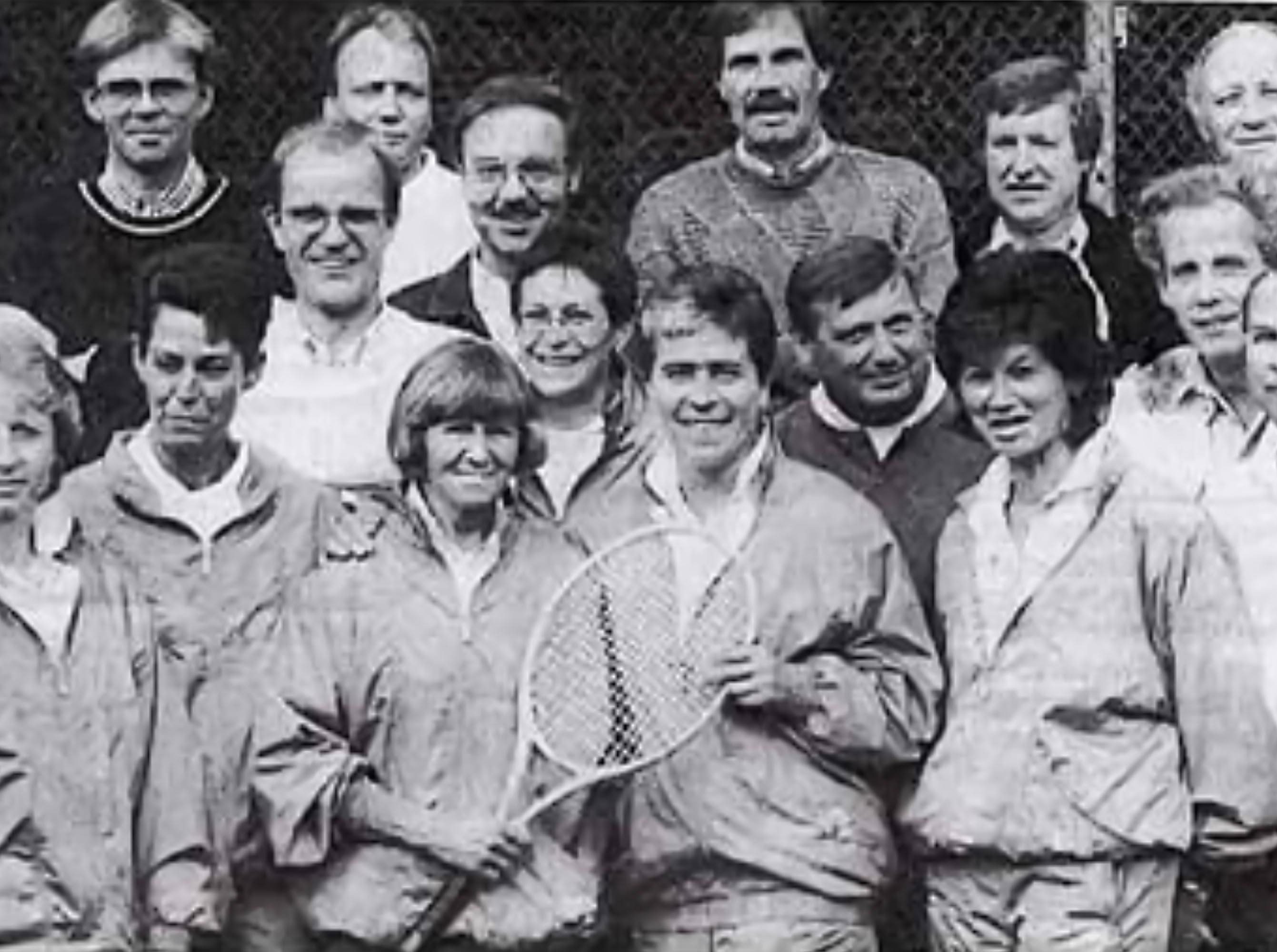 Eine Gruppe von Menschen in Sportkleidung, einige halten Tennisschl&auml;ger.